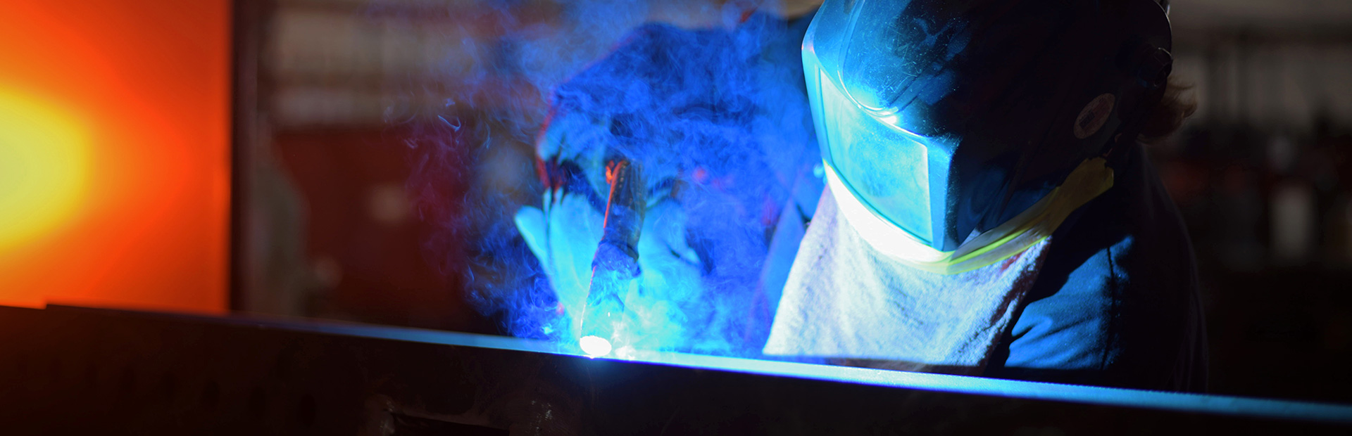 technician fabricating a piece of metal