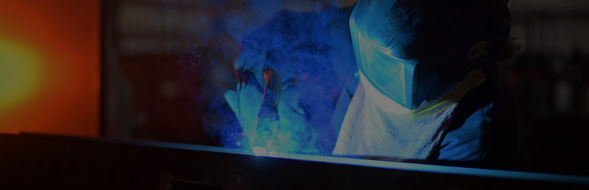 technician fabricating a piece of metal